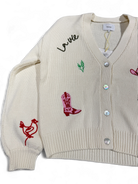 Side view of Numph Nuwally cardigan with red bird and cowboy boot motifs on sleeve