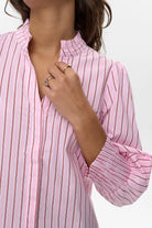 Close-up of orchid smoke pink shirt with red stripes and ruffle collar