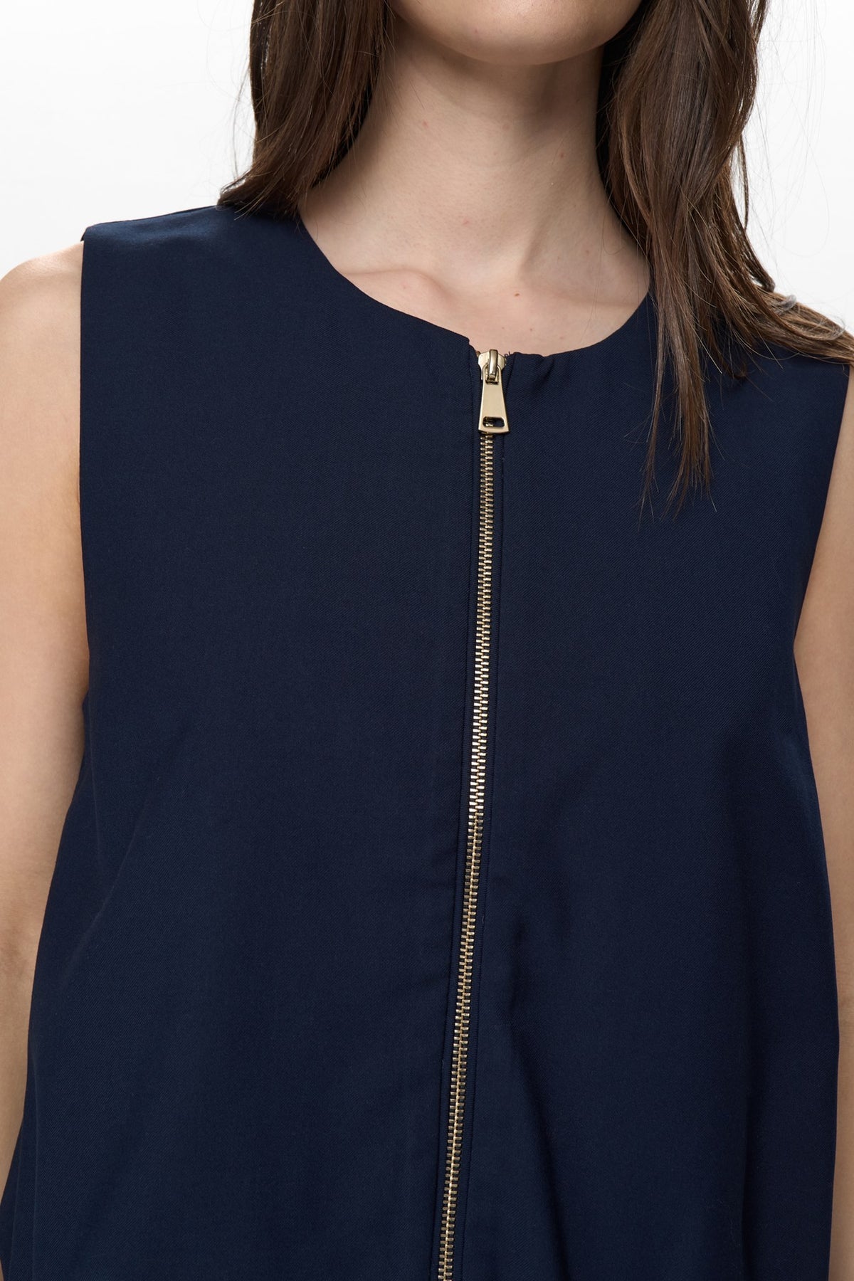 Close up of Numph Nujulia gold zip fastening on navy vest top
