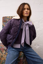 Oui violet and white striped pussy bow blouse layered under purple jacket – lifestyle view