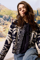 Lifestyle photo of model layering navy blouse with printed jacket outdoors
