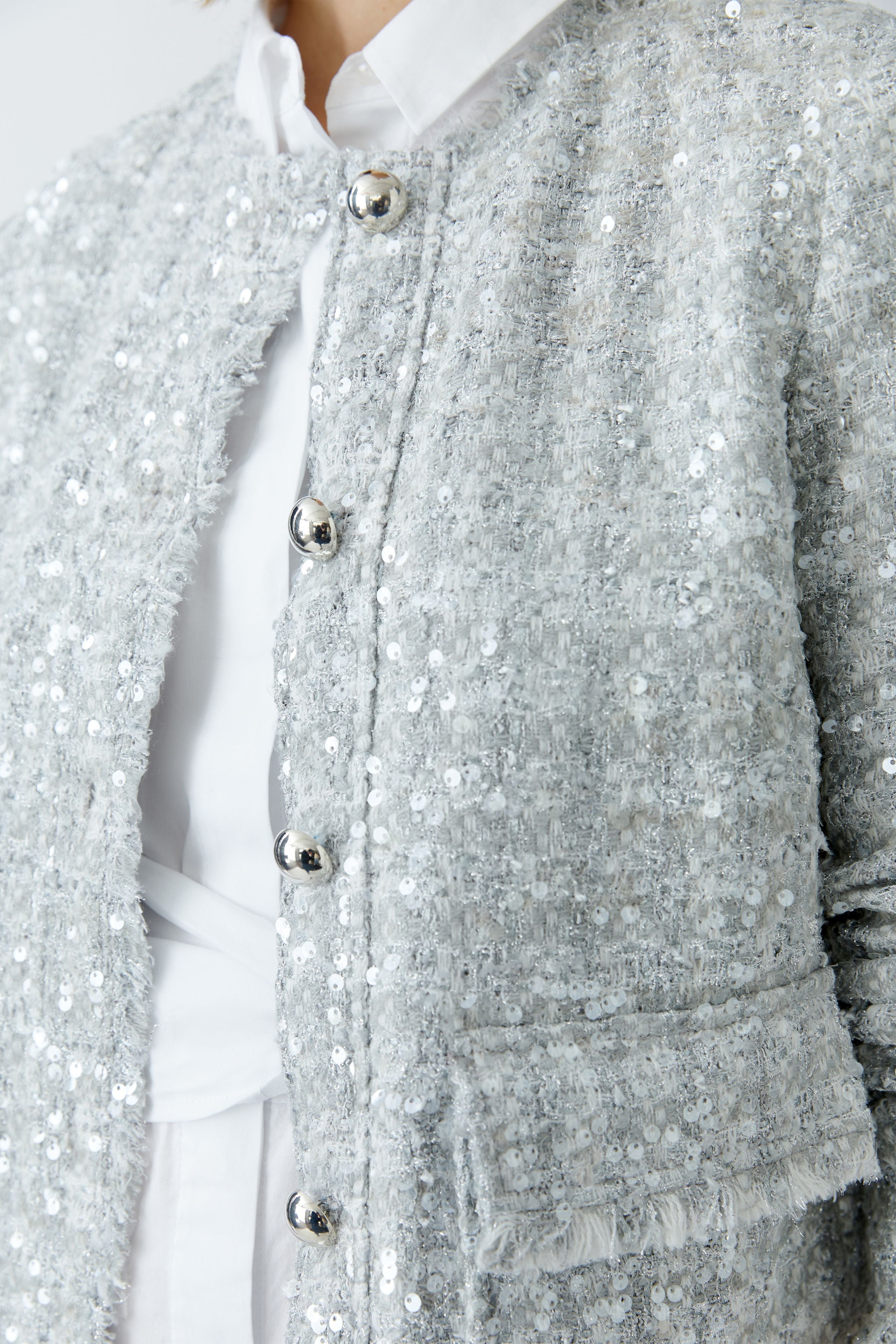 Close-up of Oui jacket’s statement button and sequin detail