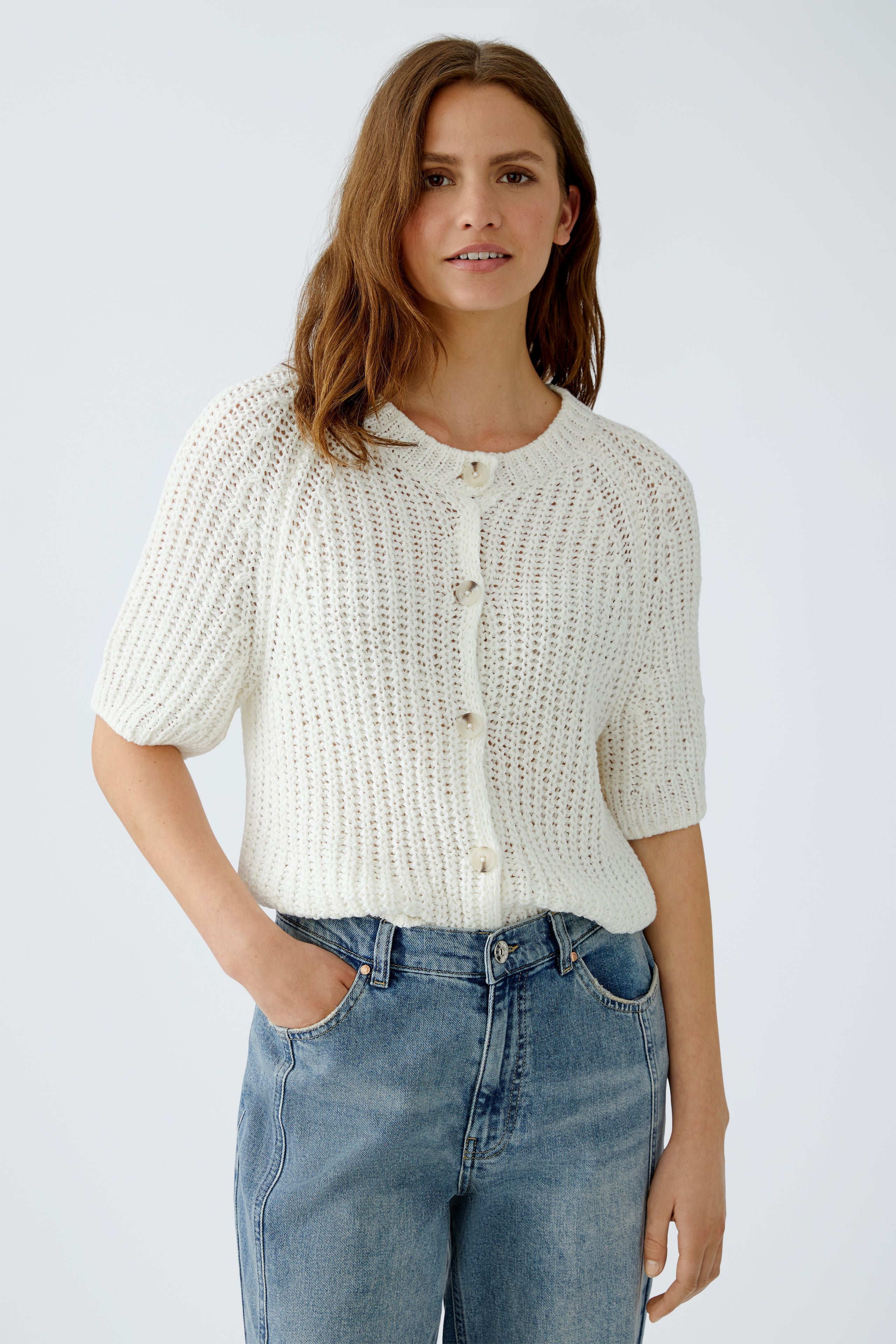 Model wearing Oui Oskar yarn summer cardigan over blue jeans