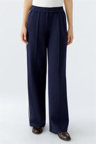 Model wearing wide-leg navy slip-on trousers with relaxed cream vest top, front view