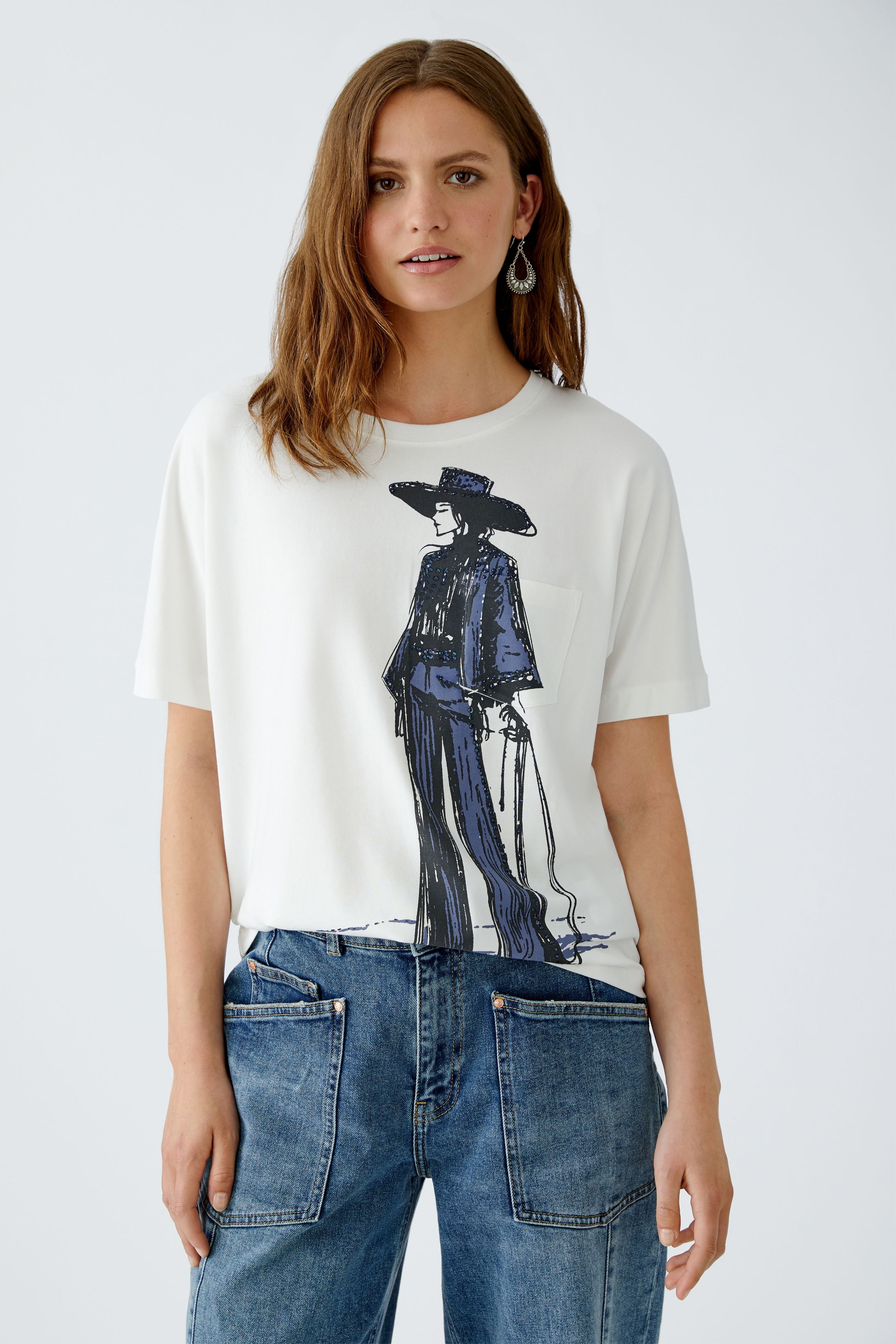 Model wearing Oui Rodeo Girl t-shirt in white with navy graphic, styled with denim jeaand