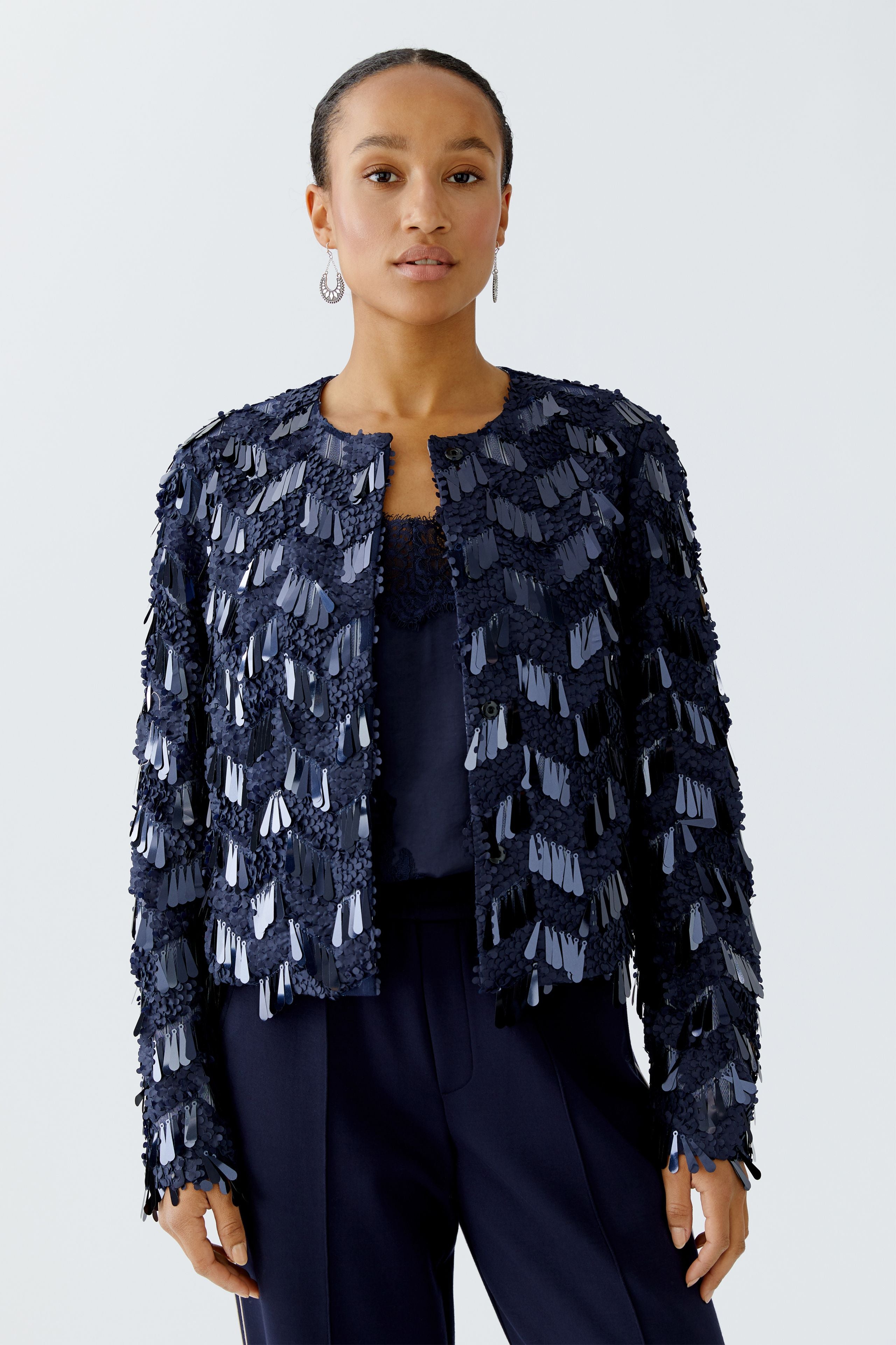 Model wearing dark blue Oui sequin jacket with navy trousers, front view