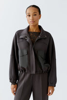 Model wearing Oui dark grey scuba jacket and matching trousers, front view