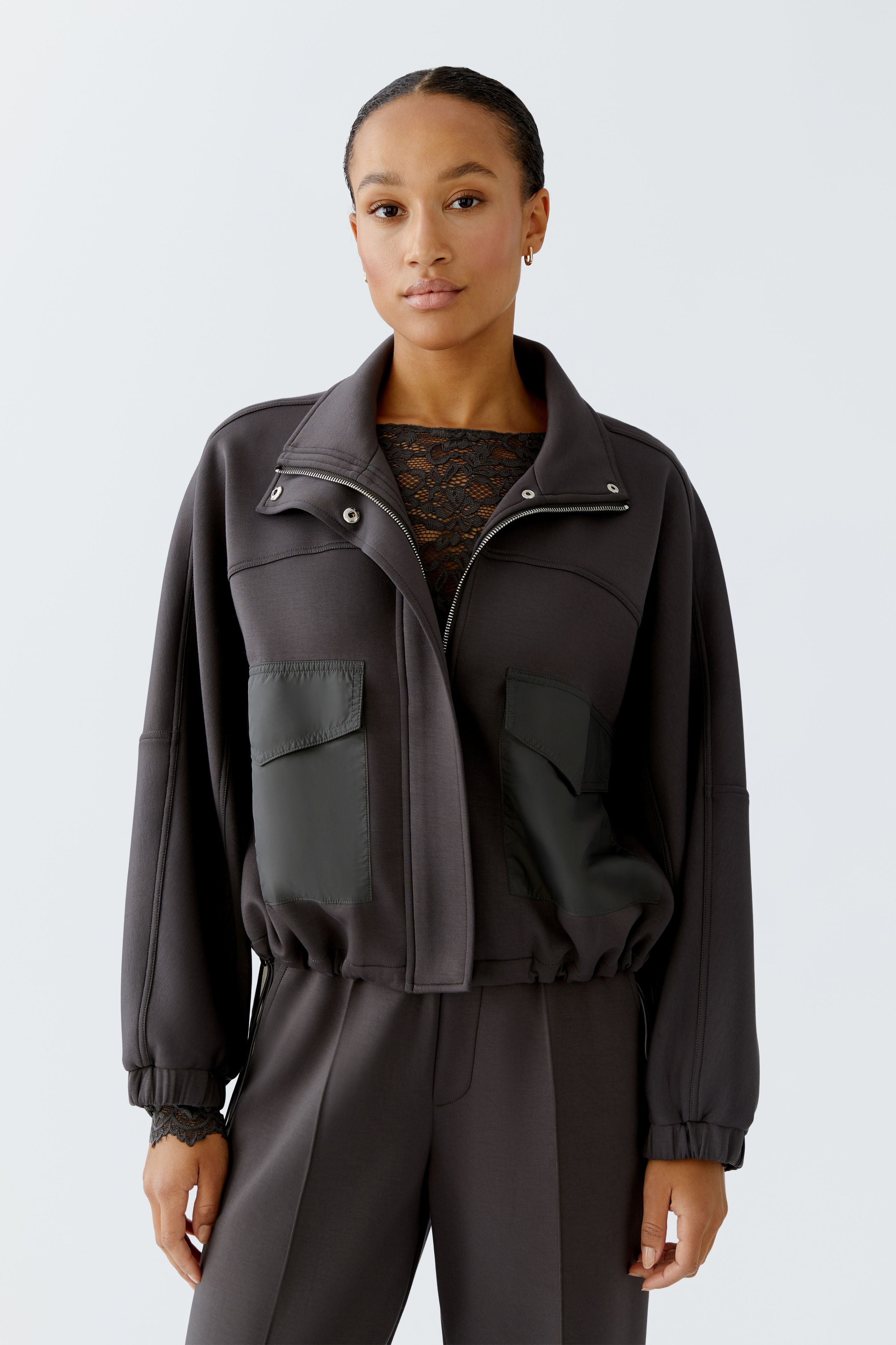 Model wearing Oui dark grey scuba jacket and matching trousers, front view