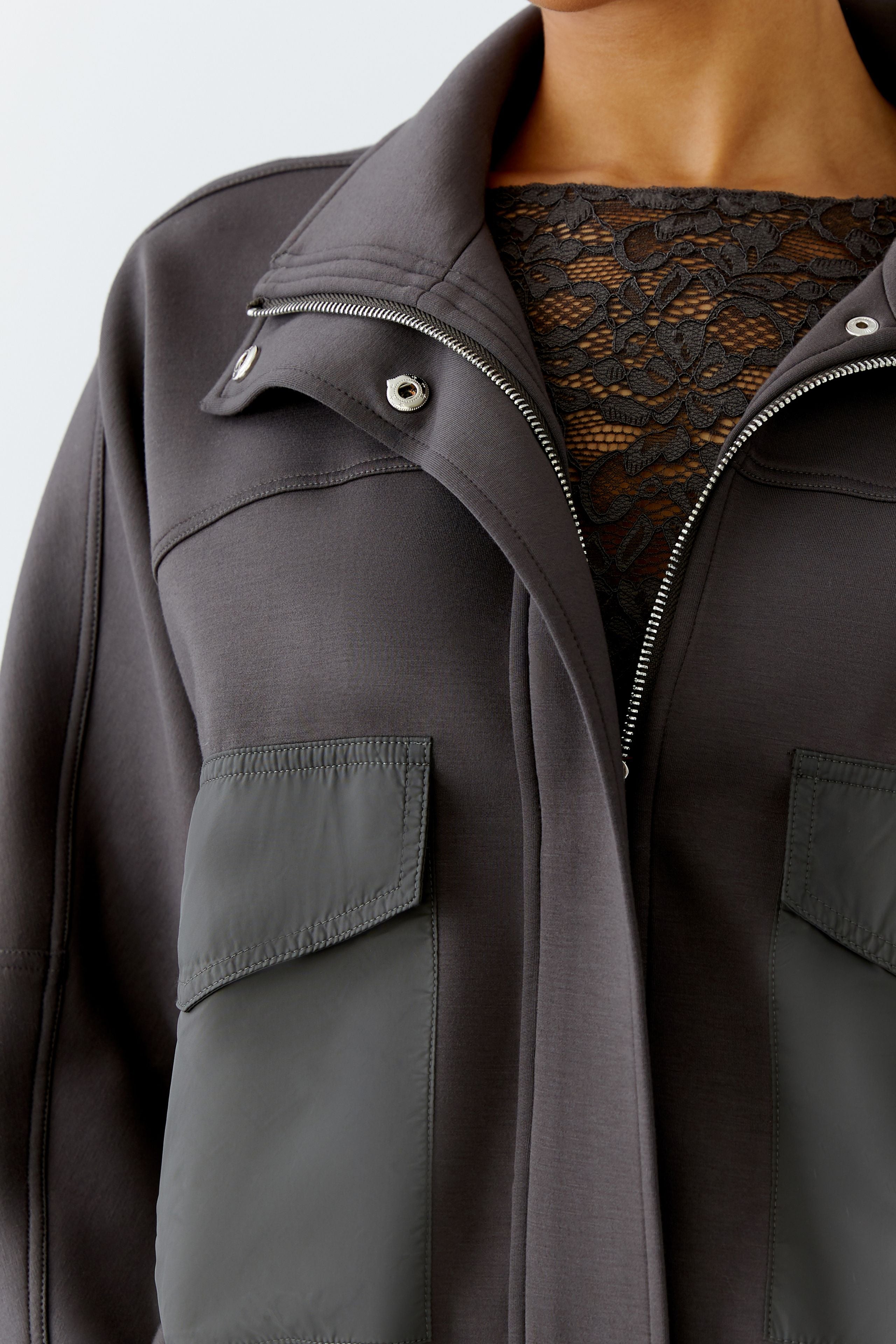 Close-up of front with contrast nylon patch pockets and zip collar