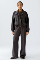Full-length view of model in dark grey scuba jacket and trousers