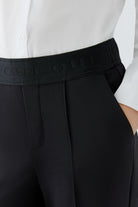 Oui NEYA black pull-on trousers with elasticated waistband, stitched crease and side pocket – detail view