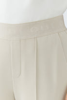 Oui NEYA cream pull-on trousers with elasticated waistband and stitched front crease – detail view
