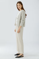 Oui NEYA cream cropped trousers styled with coordinating cardigan – side model view