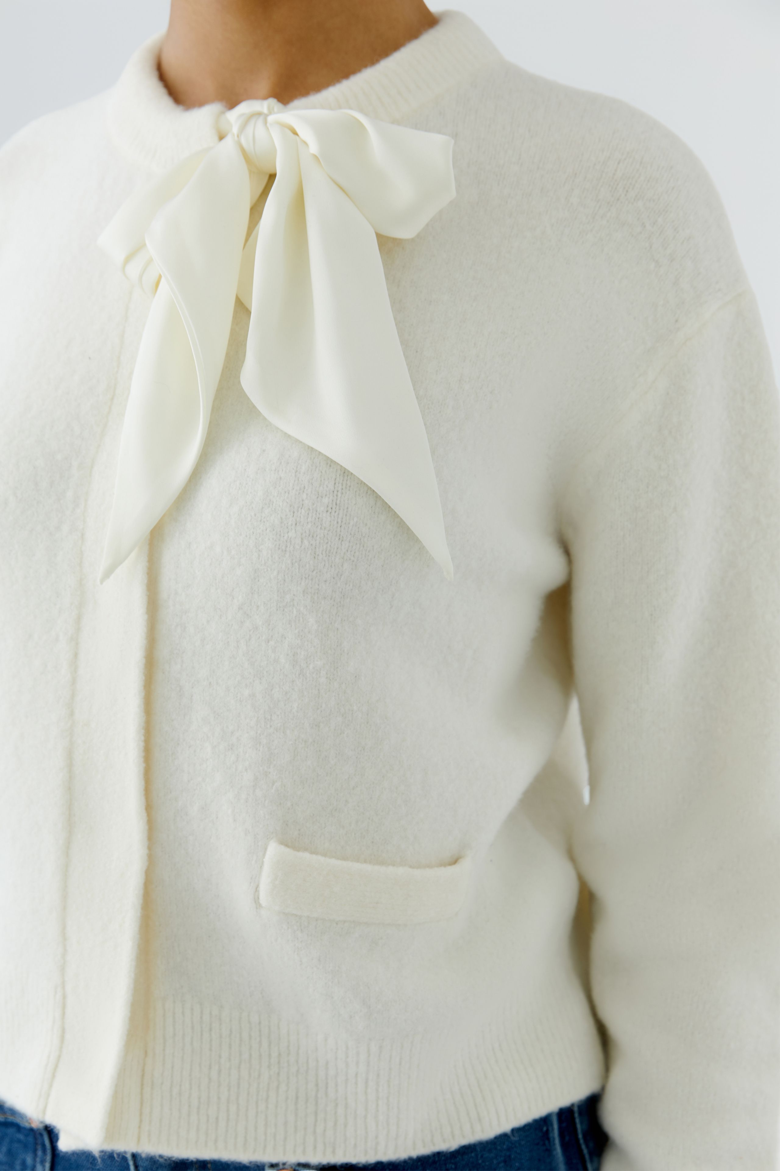 Oui cream satin bow cardigan with decorative front pocket detail – close-up