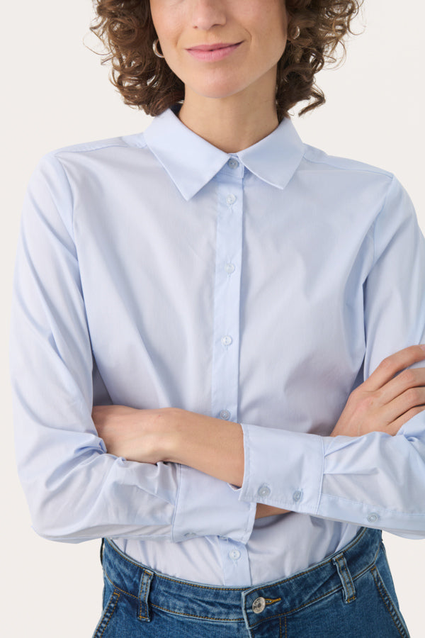 Model wearing Part Two Nimini shirt in heather blue with sleeves rolled up