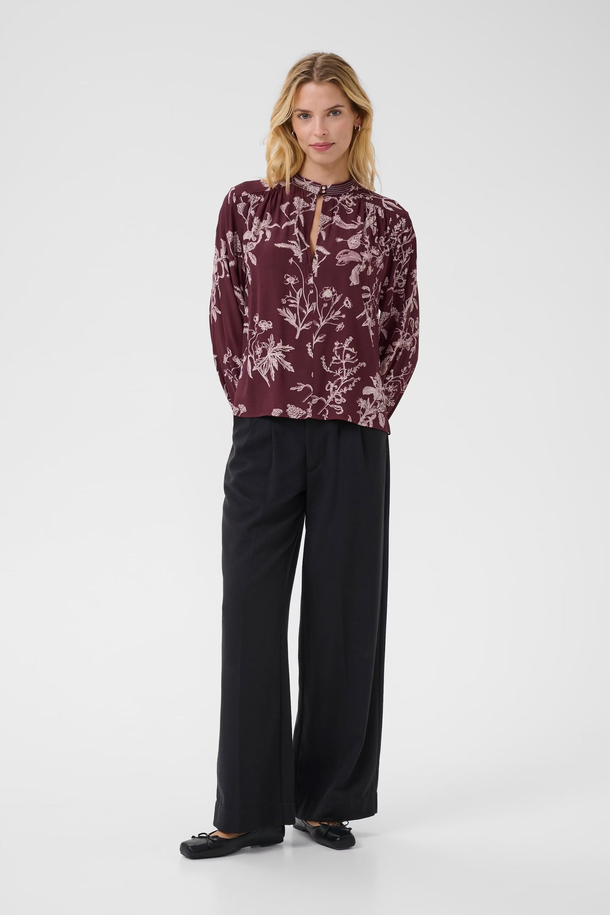 Model wearing Part Two burgundy floral blouse with relaxed long sleeves