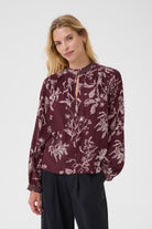 Front view of model in Part Two Shiroma blouse styled with black trousers