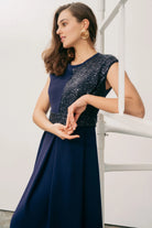 Close-up of Sisters Feya ink blue dress showing the sequin panel and defined waist