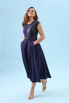 Full-length view of Sisters Feya ink blue sequin fit and flare midi dress with pockets