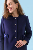 Close-up of crystal buttons and bow pocket detail on Olivia occasion coat