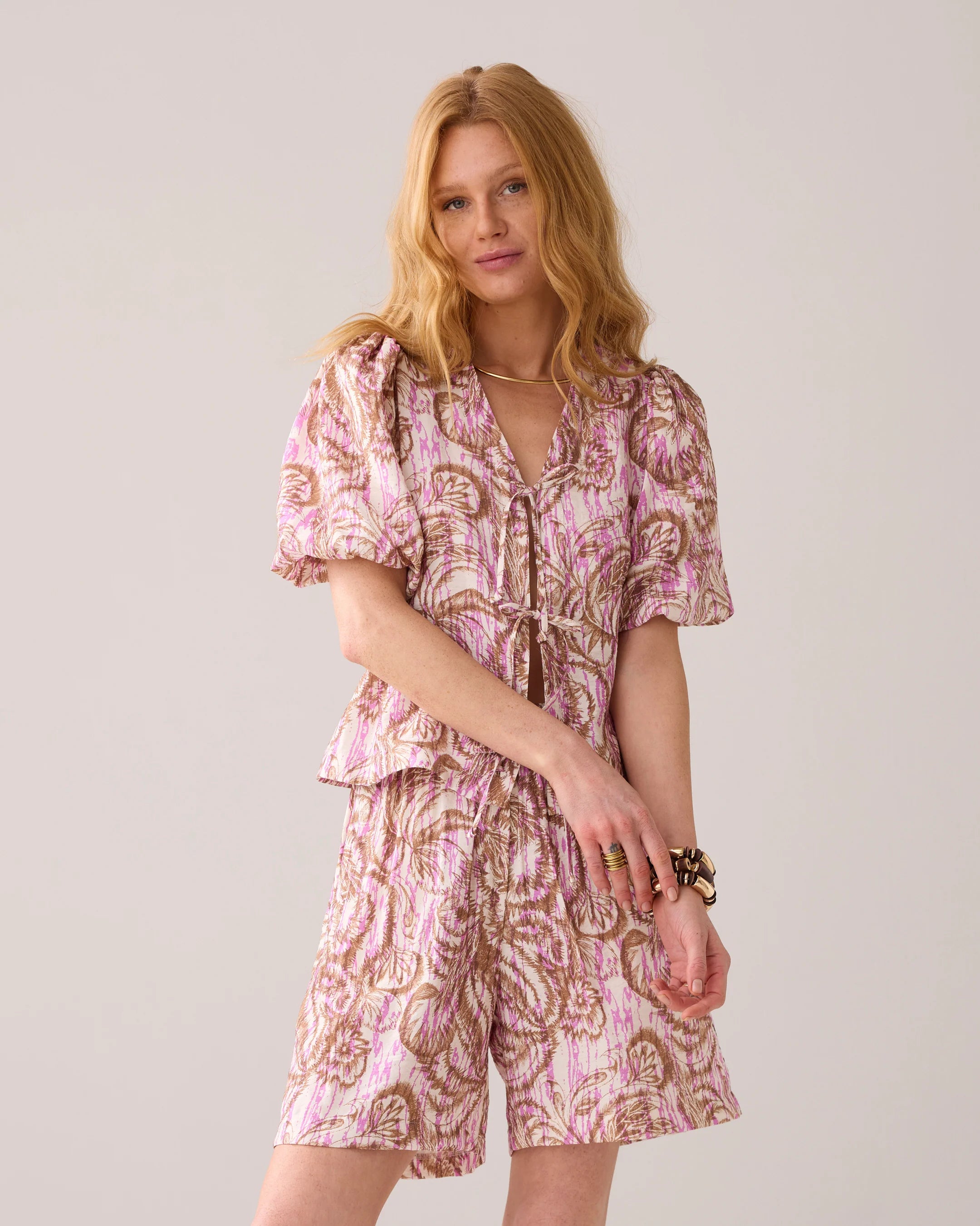 Model wearing Summum pink botanical co-ord set with tie-front blouse and shorts