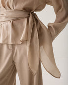 Close-up of Summum wrap waist tie detail top with long sleeves
