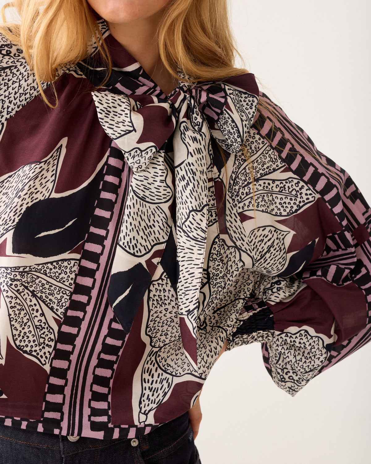 Close-up of Summum floral bow blouse neckline and print