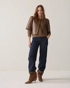 Summum short brown faux leather jacket styled with navy trousers and brown boots – full model view