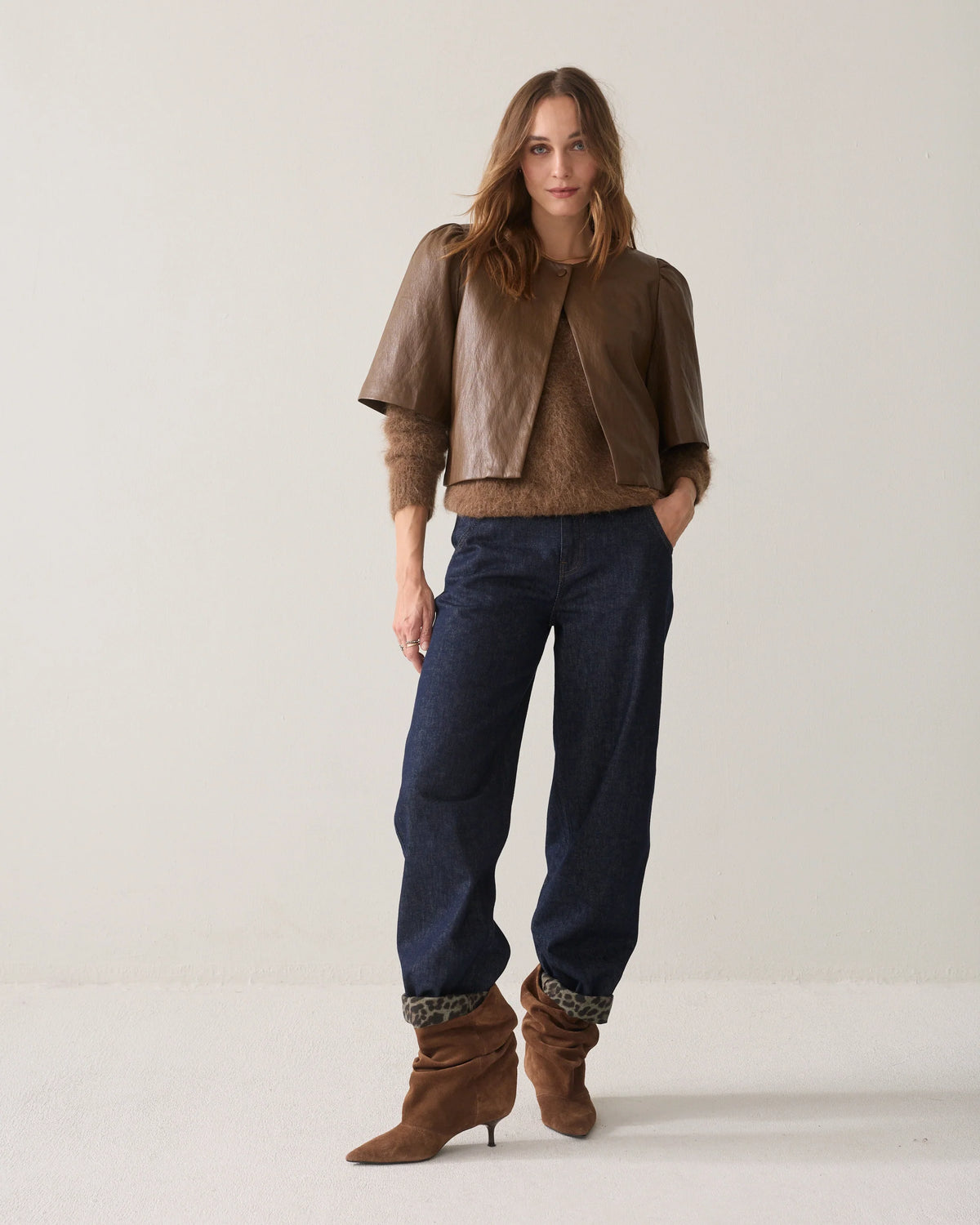 Summum short brown faux leather jacket styled with navy trousers and brown boots – full model view