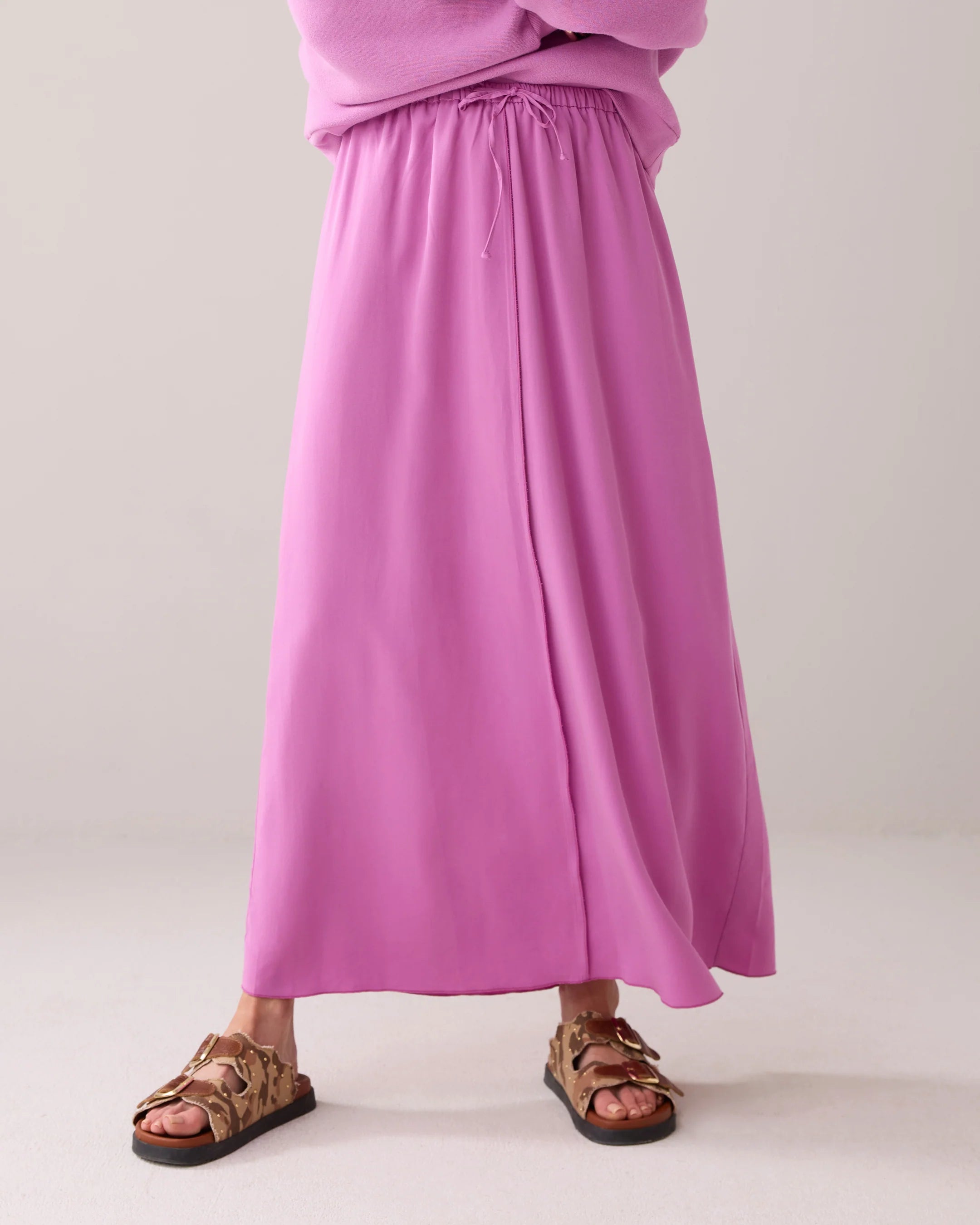 Close-up front view of Summum long pink Tencel skirt with soft sheen and gathered waistband