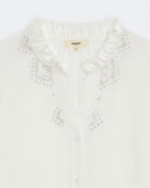 Close up of frilled neckline on cream blouse with embroidered sleeves by Suncoo