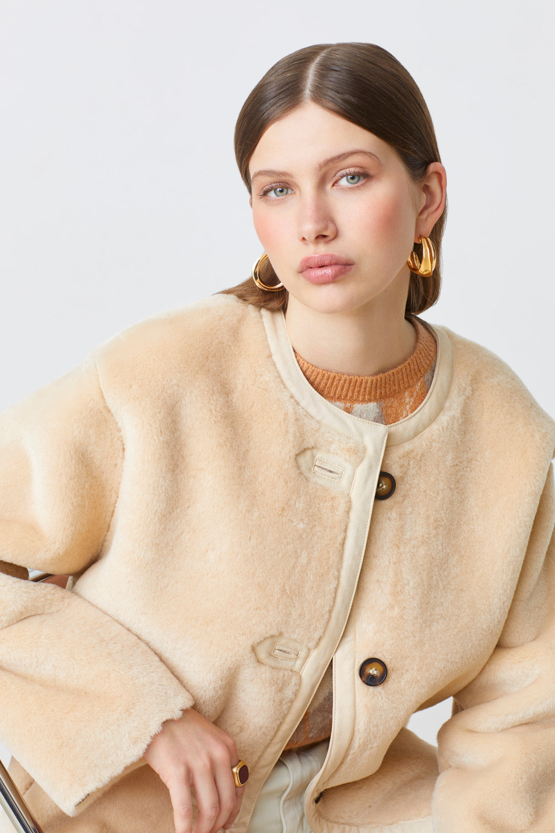 Women’s cream winter jacket with collarless neckline and contrast buttons