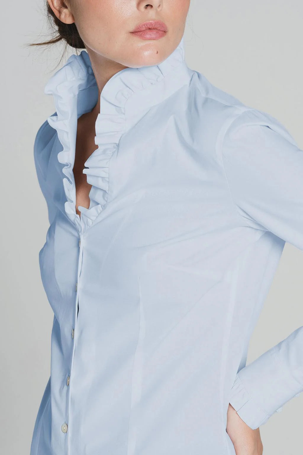 Model wearing light blue Tinta Lucar frill detail shirt with black trousers