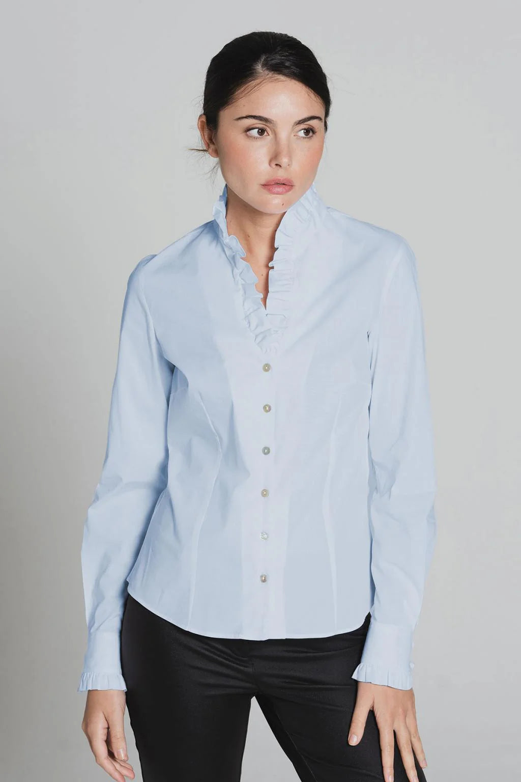 Front view of light blue Tinta Lucar blouse with frill neckline
