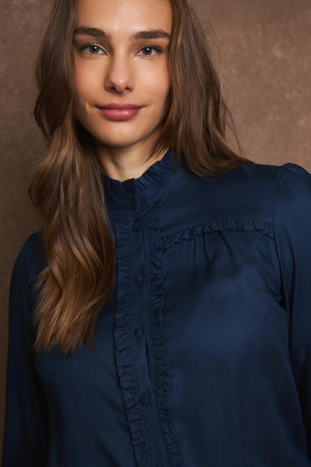 Close-up of frill trim and covered buttons on navy Victoria blouse by Tinta