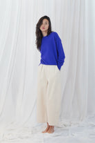 Twins Aurora cobalt blue relaxed jumper styled with cream trousers