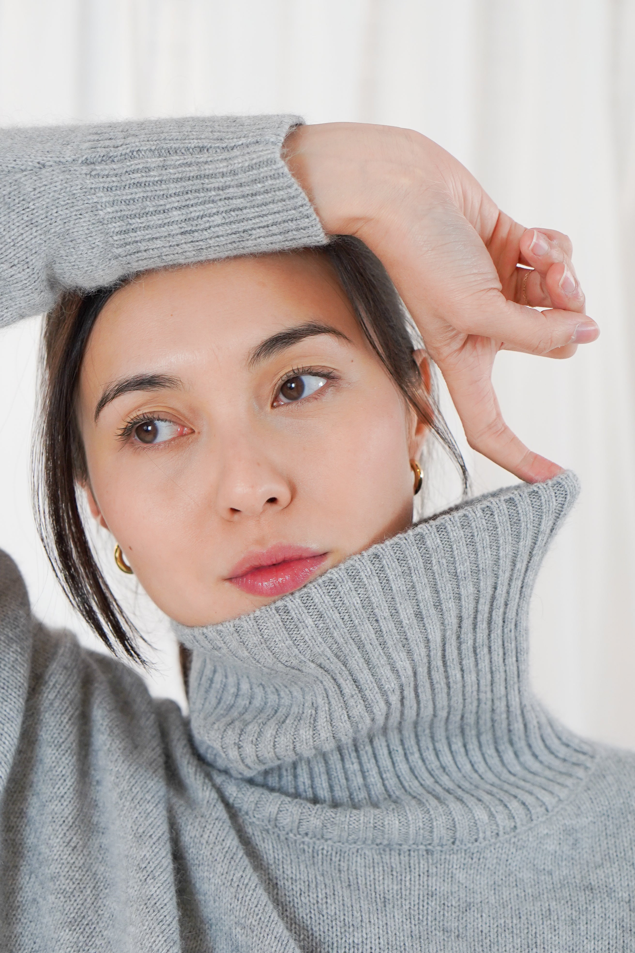Close-up portrait of Twins Greeley grey roll neck jumper