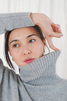Close-up portrait of Twins Greeley grey roll neck jumper