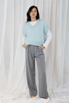 Twins Queens white crew neck long sleeve T-shirt layered under a blue knitted vest