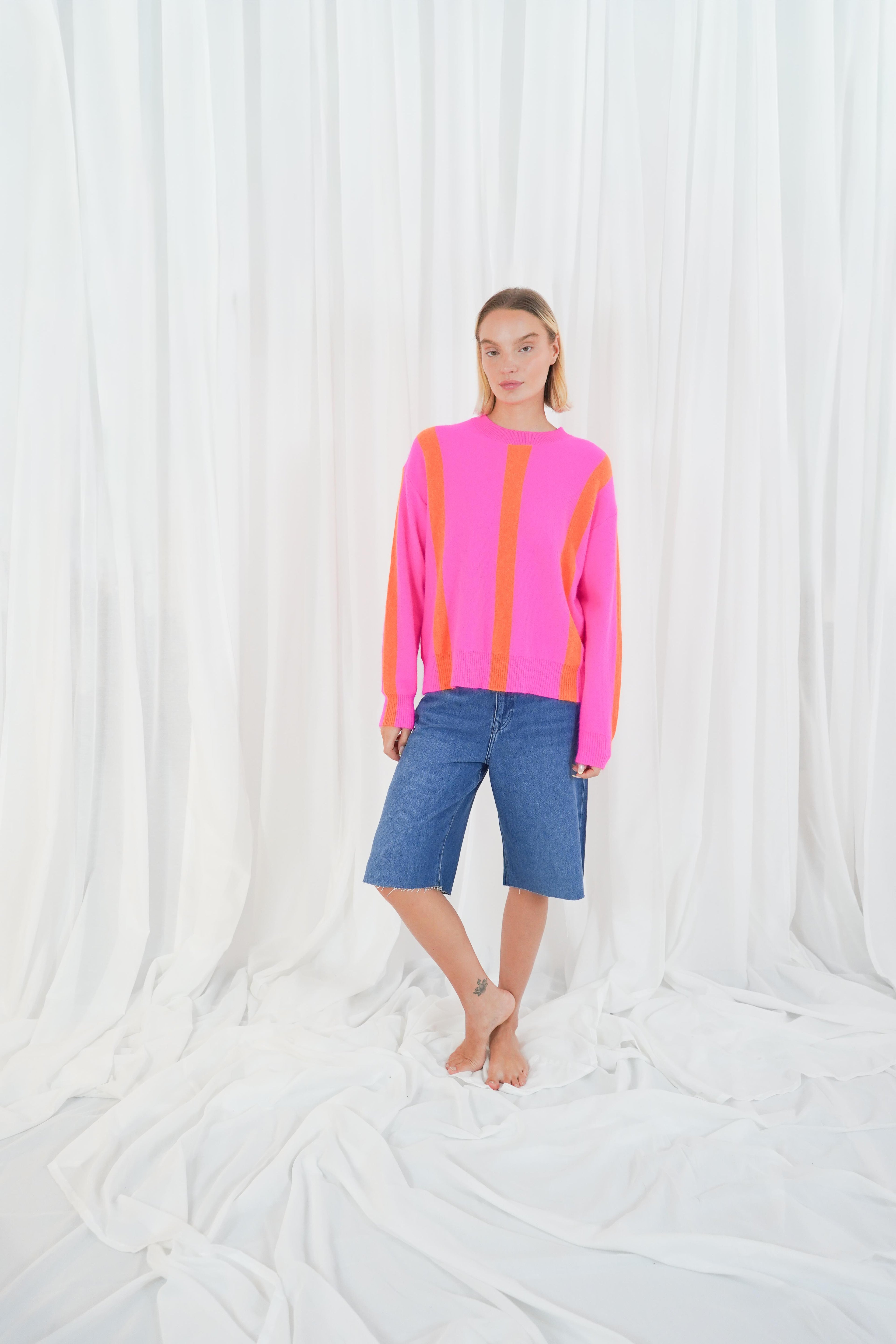 Twins Reno pink and orange striped jumper styled with denim shorts