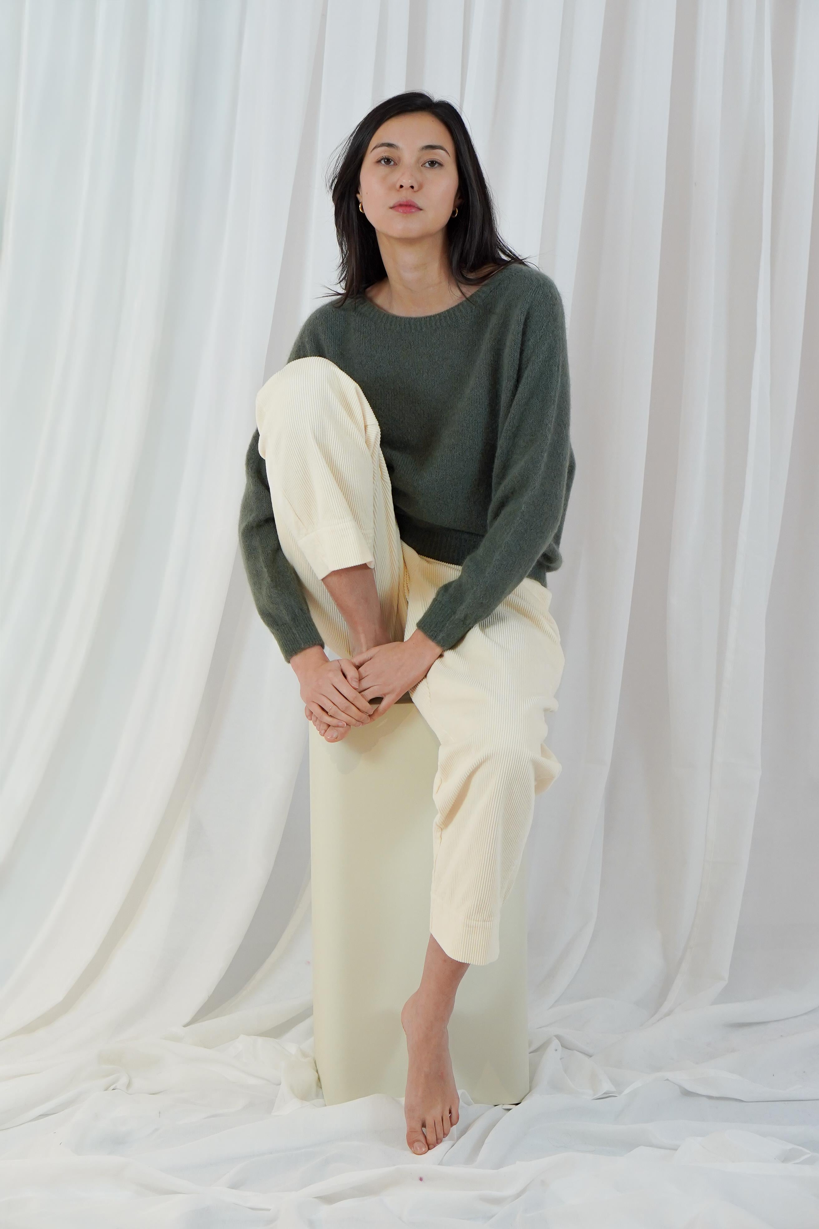 Twins Sanibel forest green relaxed jumper styled with cream trousers
