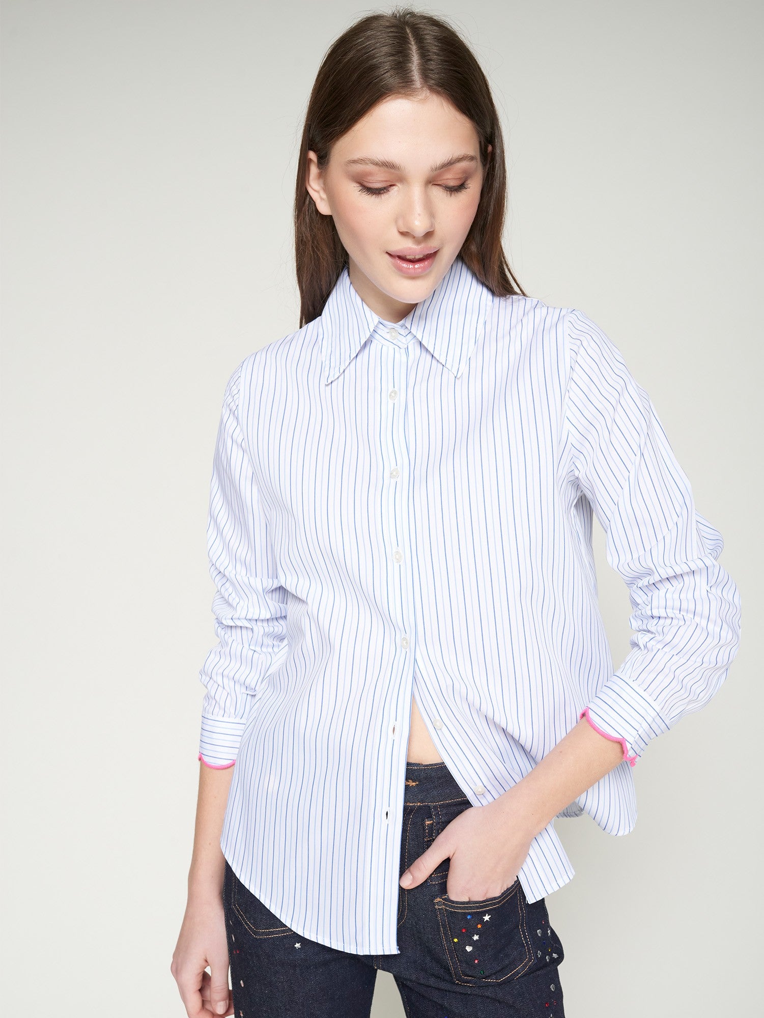 Model wearing Vilagallo blue and white striped shirt with pink scalloped cuffs