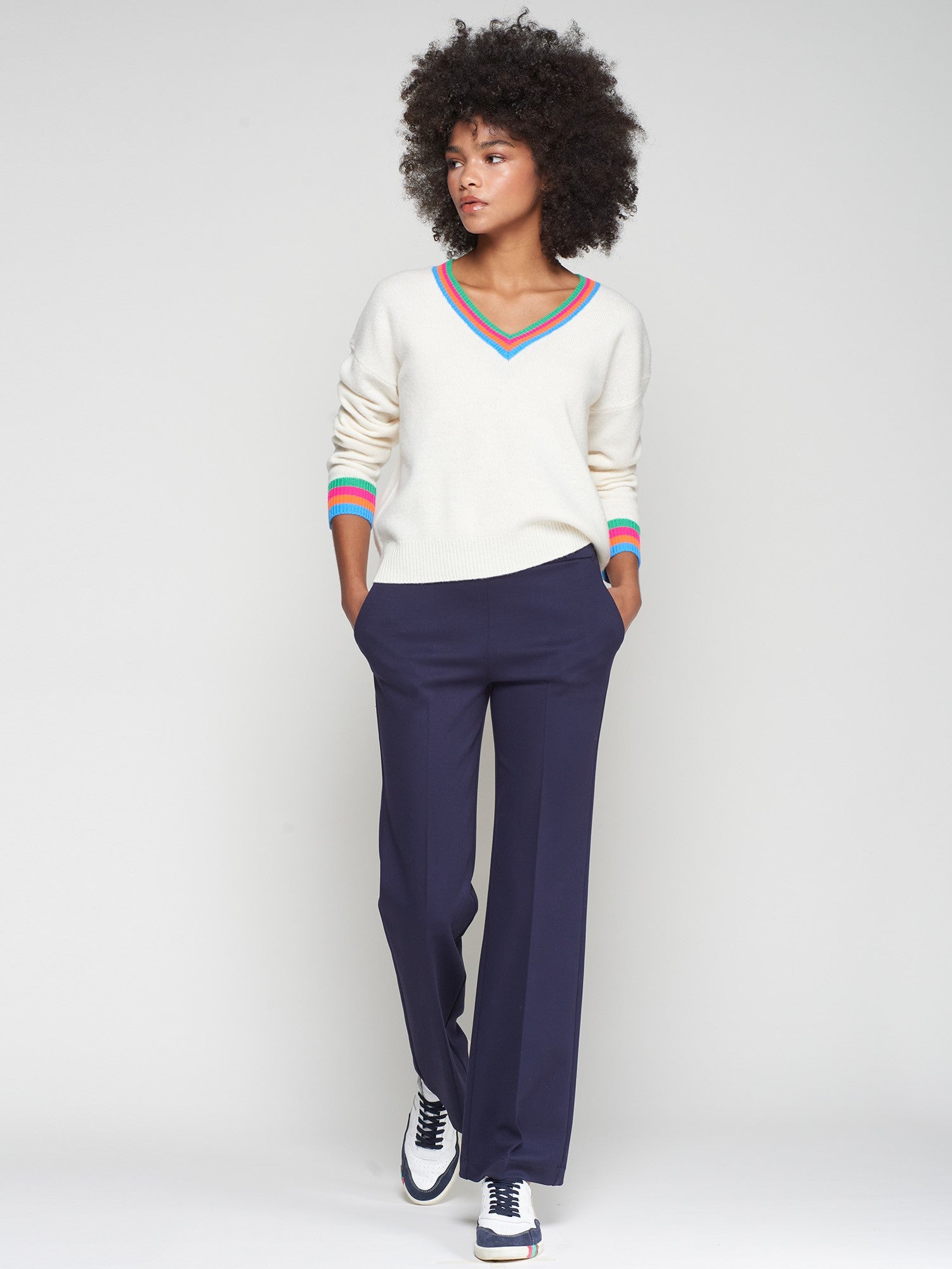 Model in straight-leg navy trousers with clean waistband and front crease, hands in pockets.