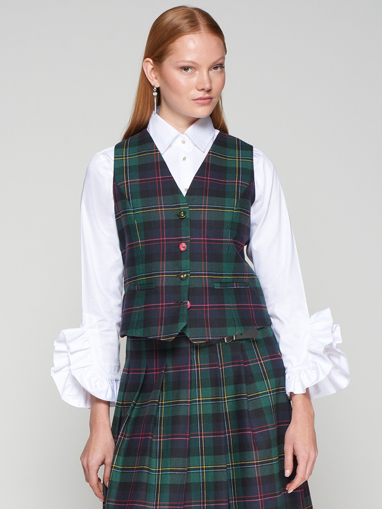 Structured white blouse featuring voluminous cuff ruffles and gold button front