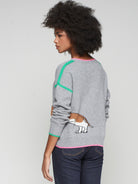 Women’s grey wool dachshund sweater by Vilagallo with pink trim and green stripes.