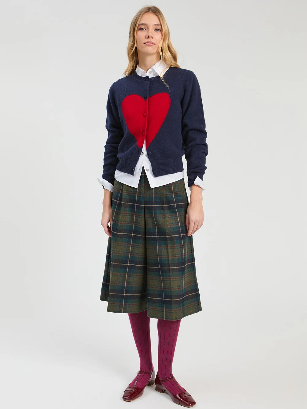 Vilagallo navy red heart cardigan styled with white shirt and checked skirt – full model view