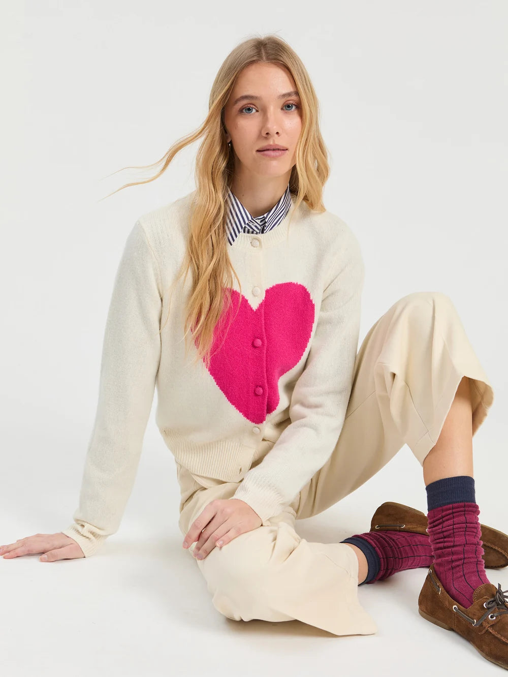 Vilagallo ecru heart intarsia cardigan with fuchsia heart – seated model view